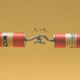 يظهر مقياسي النابض قوة متساوية عند سحبه بعيداً عن بعضه